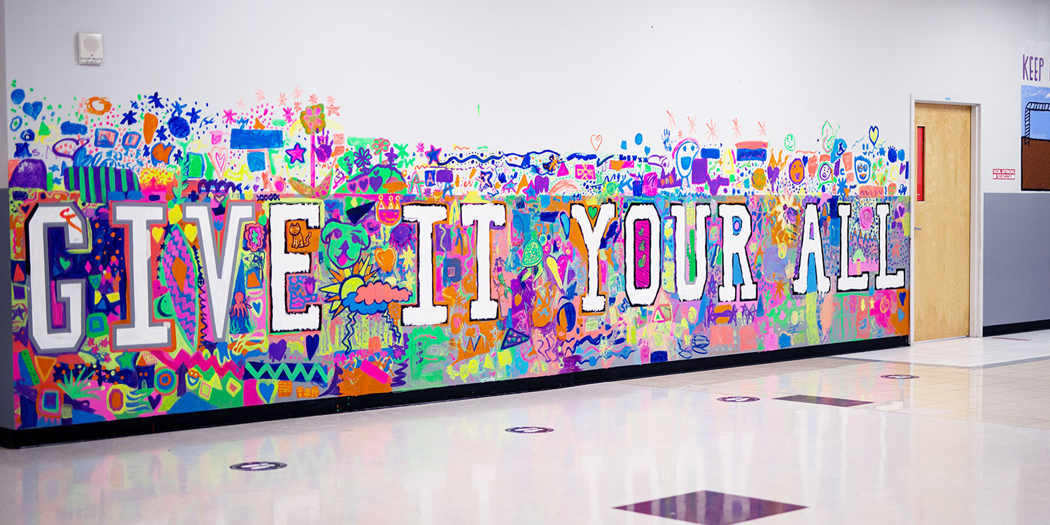 "Give It Your All" bright neon hallway mural.